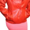 A woman wearing a Women's Soft Genuine Red Leather Short Buttons Closure Fitted Jacket Style and pink skirt.