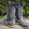 A pair of Men's Genuine Cowhide Coco Belly Print Leather Square Toe Boots Handcrafted on a sidewalk.