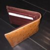 A Genuine Ostrich Skin Leather Men's Bifold Wallet Made In USA with a credit card.